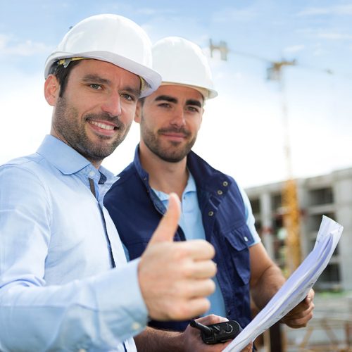 View of a Engineer and worker watching blueprint on construction site